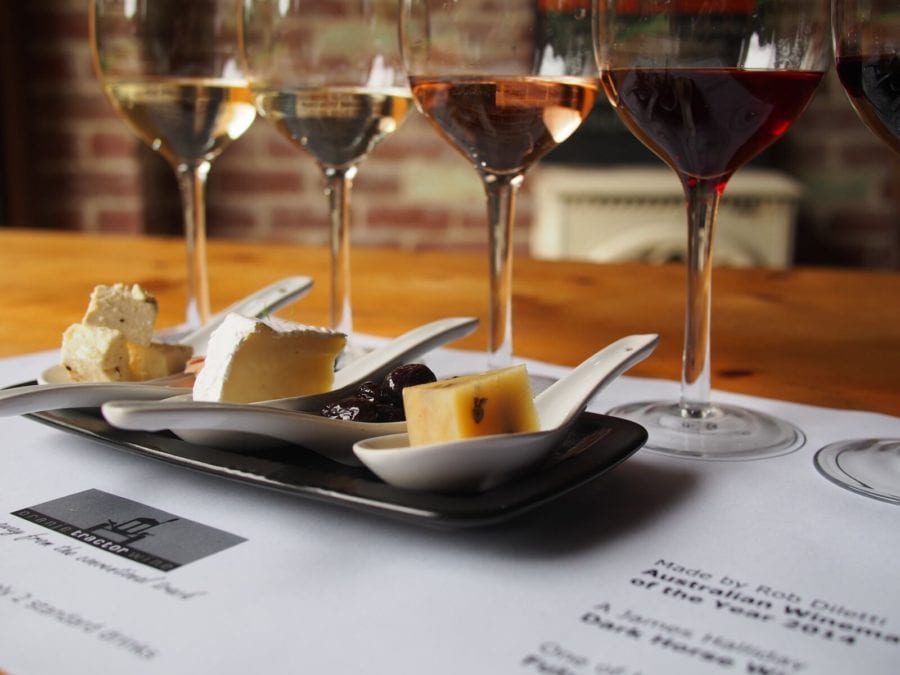 four glasses of wines with small portions of food